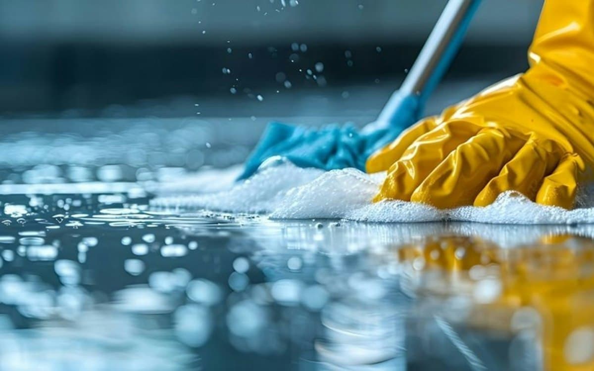 Close-up of a gloved hand cleaning a floor