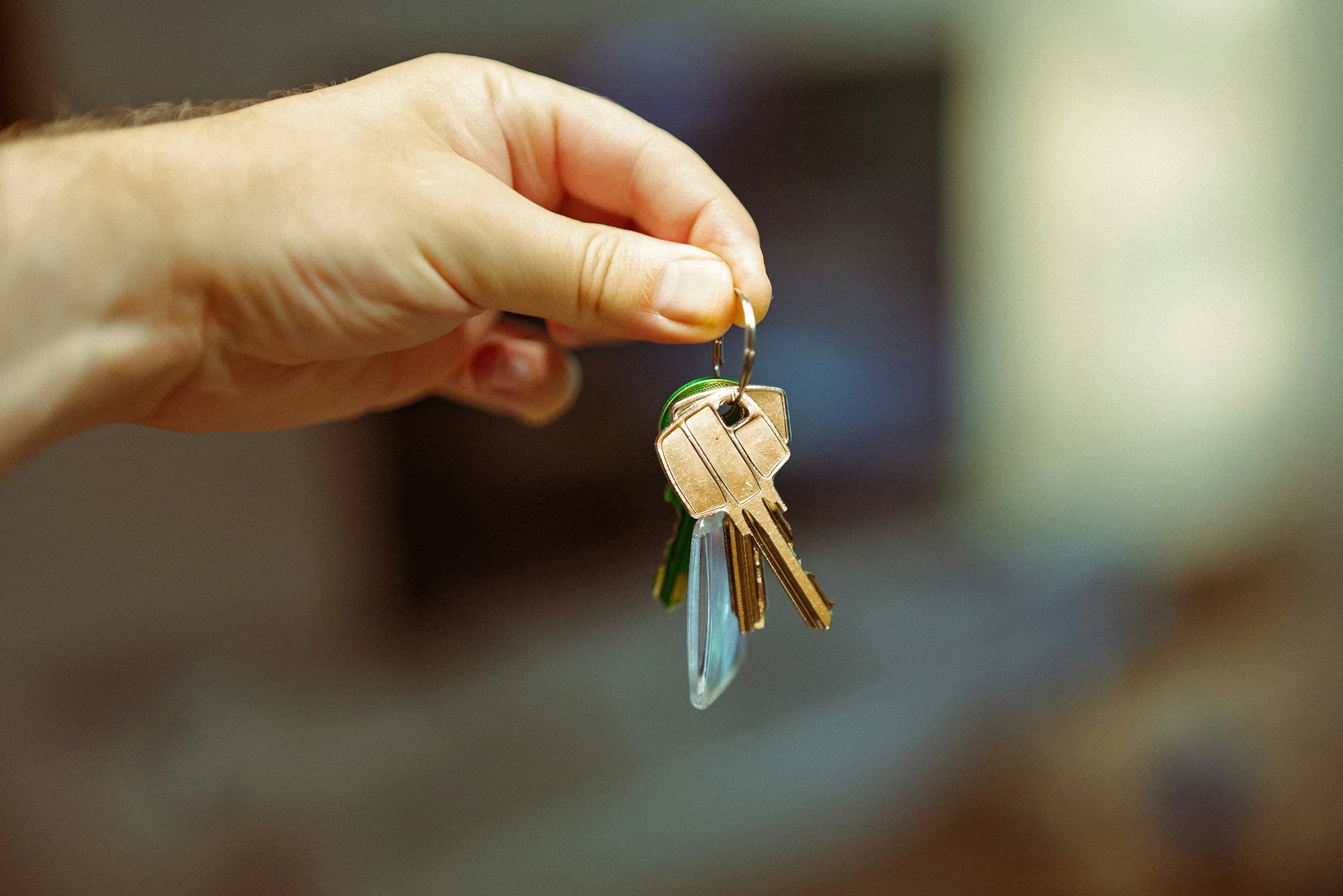 A hand holding out a set of keys